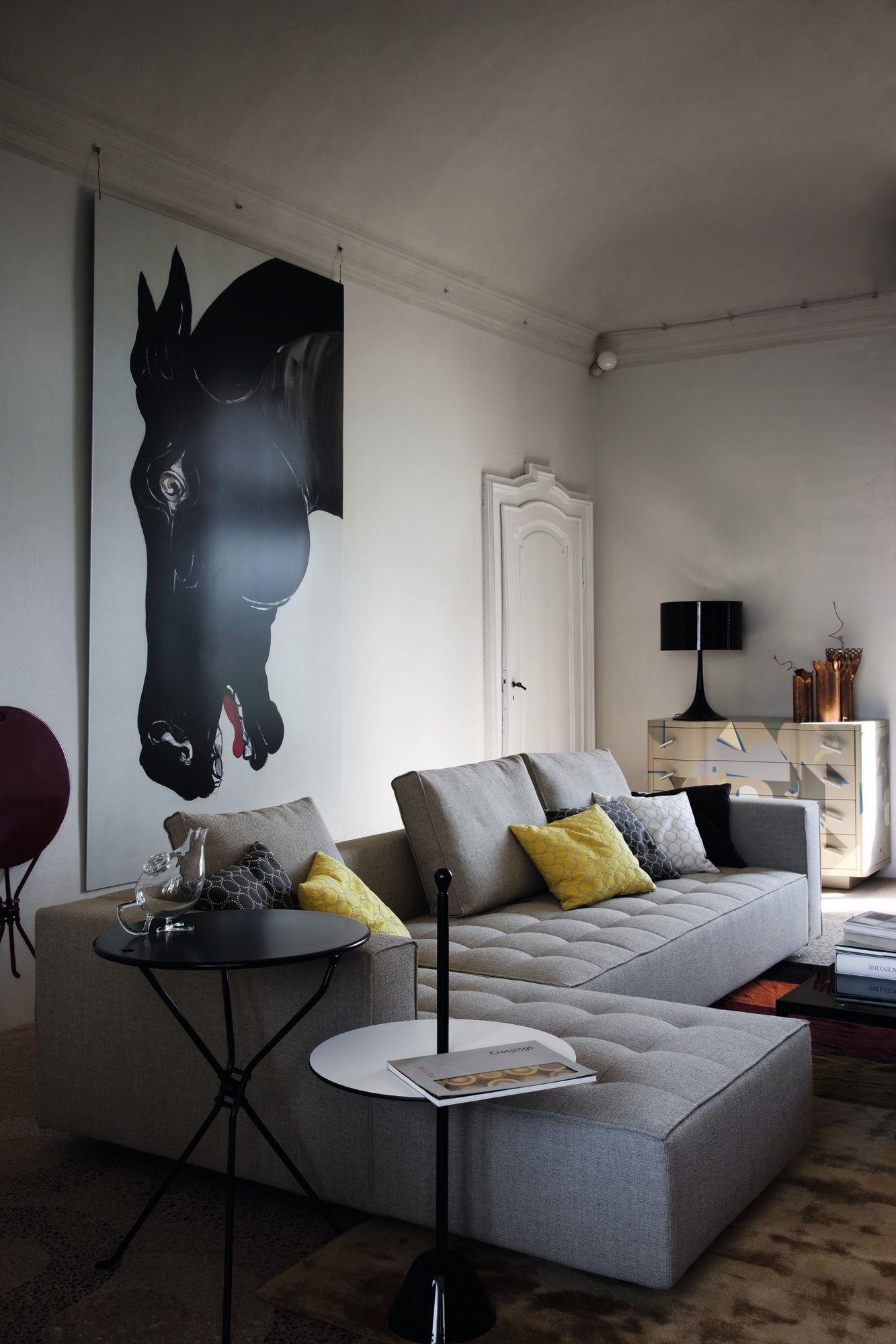 Schwarzer Servomuto Beistelltisch von Zanotta neben einem grauen Sofa in einem modernen Wohnzimmer.