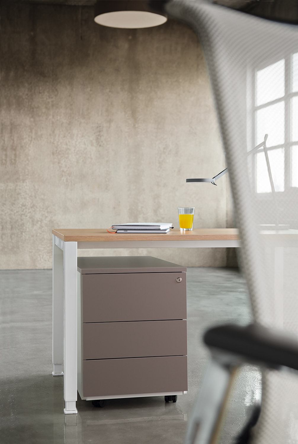 Rollcontainer von König+Neurath in Grau unter Schreibtisch mit drei Schubladen und Rollen.