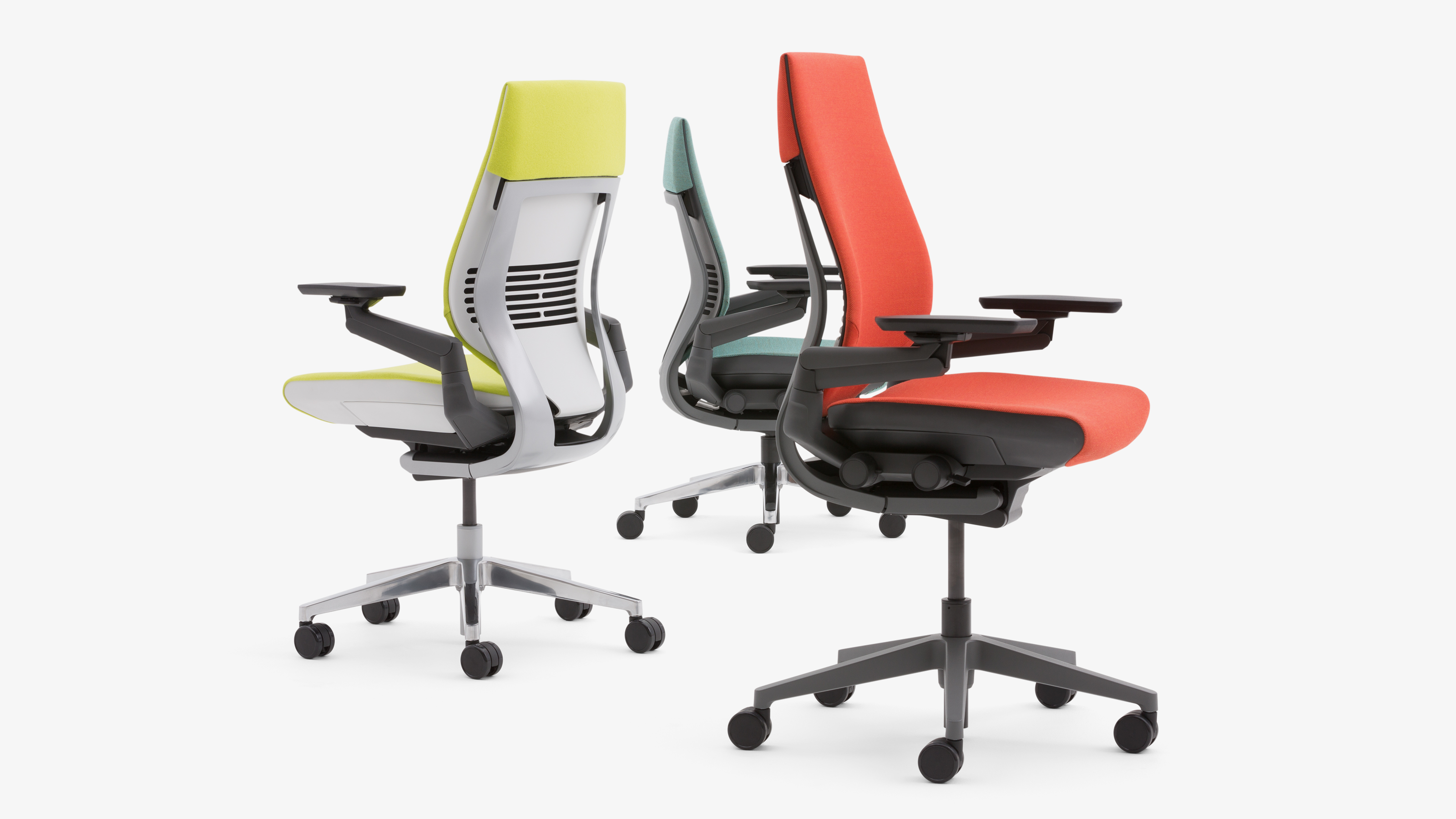 Drei Steelcase Gesture Bürostühle mit Stoffbezug in Grün, Blau und Rot auf weißem Hintergrund.