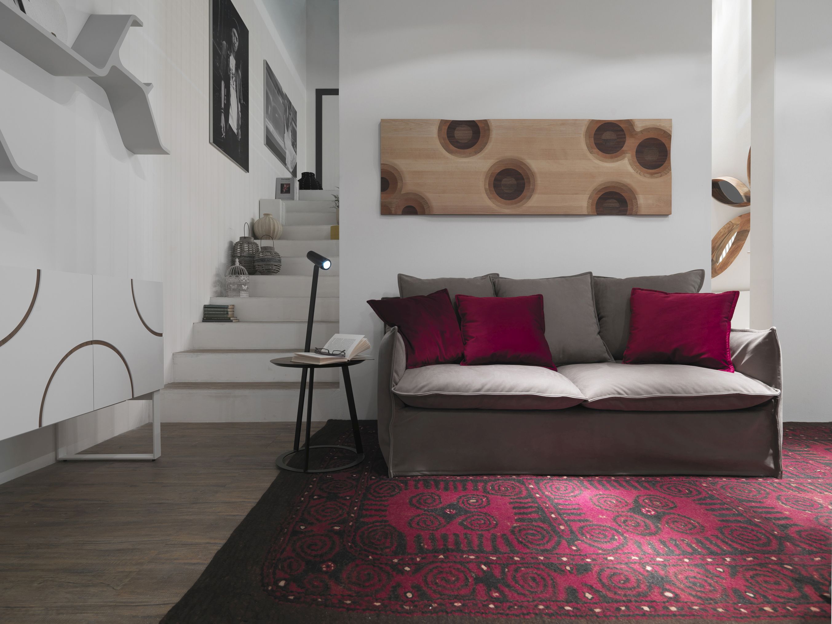 Albino Torcia Beistelltisch mit Walnussplatte und schwarzem Gestell neben Sofa im Wohnzimmer.