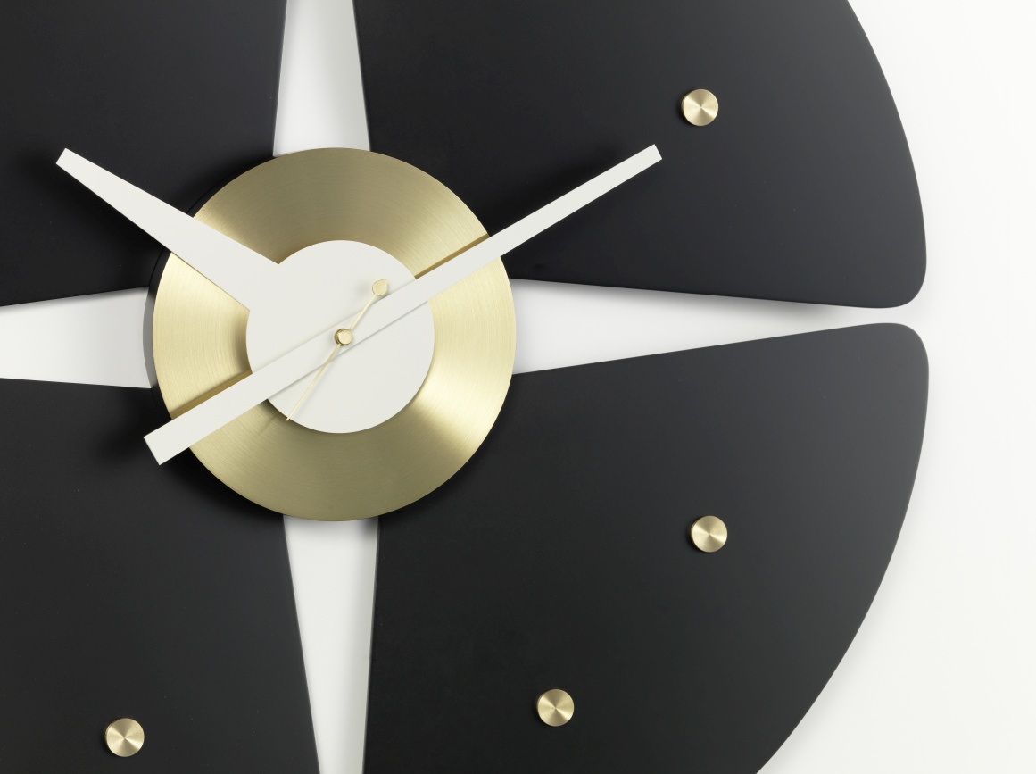 Detailaufnahme der Petal Clock Wanduhr von Vitra mit schwarzen Blütenblättern und goldenem Ziffernblatt.