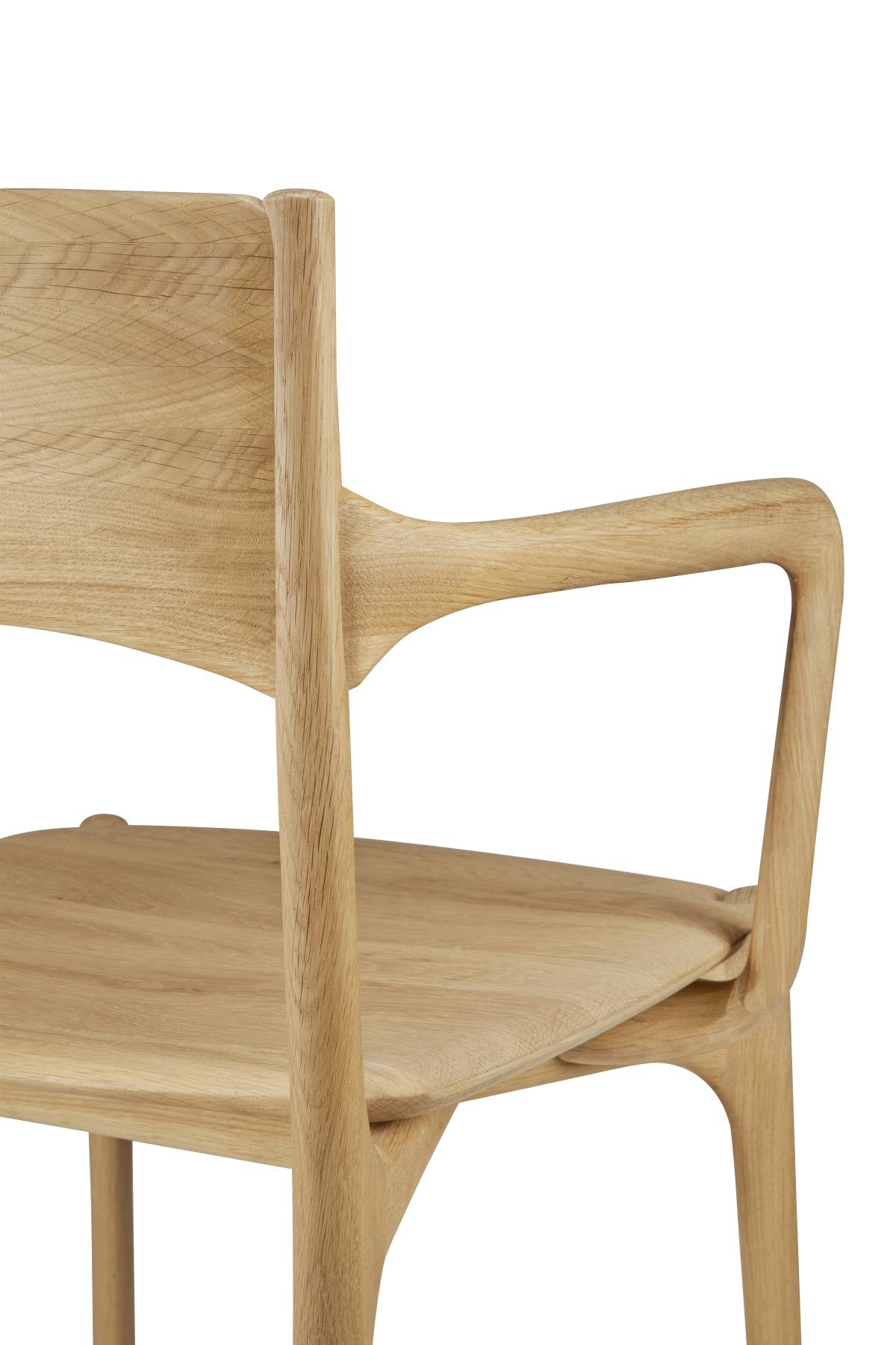 Detailaufnahme des Ethnicraft PI Dining Chair mit Armlehne aus hellem, massivem Eichenholz.