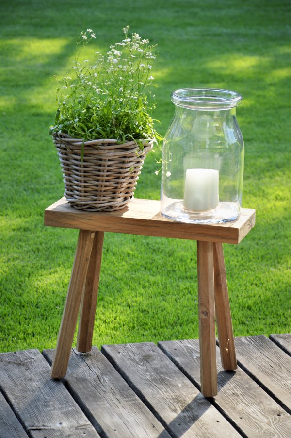 Milo Hocker von Jan Kurtz im Garten mit Pflanze und Windlicht auf Holzterrasse.
