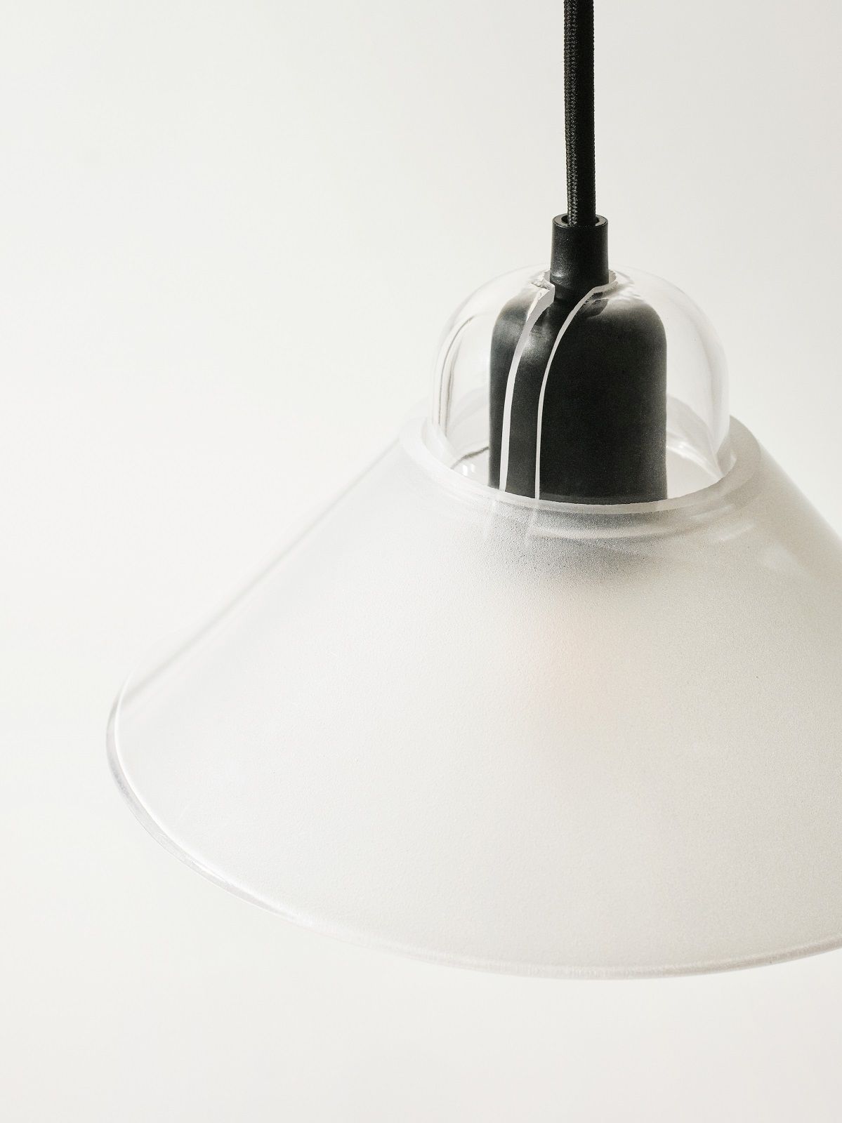 Kalo Lampe von Design House Stockholm: Pendelleuchte mit mattiertem, transparentem Lampenschirm und schwarzem Kabel.