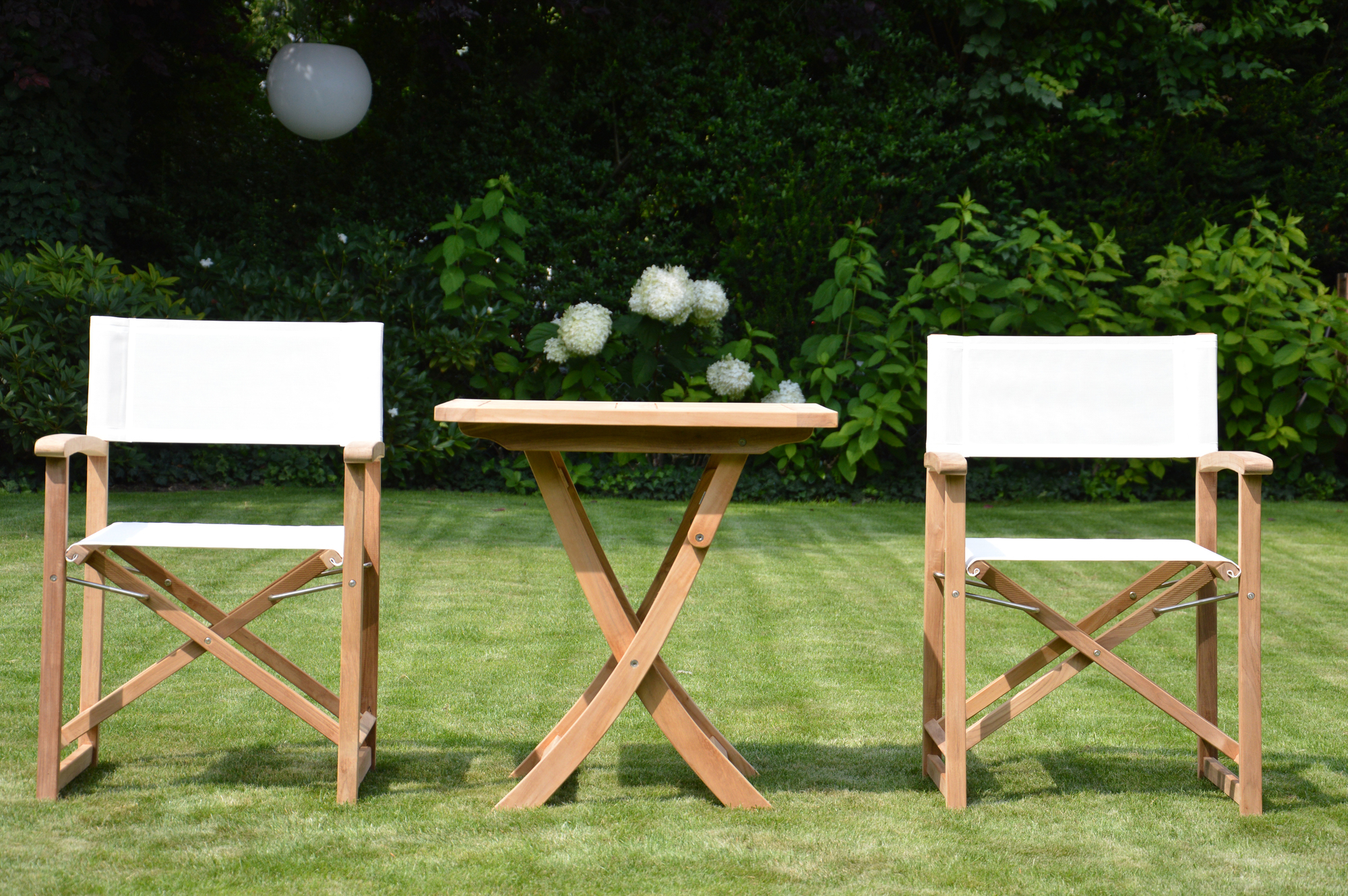 Urban Regiesessel von Jan Kurtz mit weißem Bezug und passendem Holztisch für den Garten.