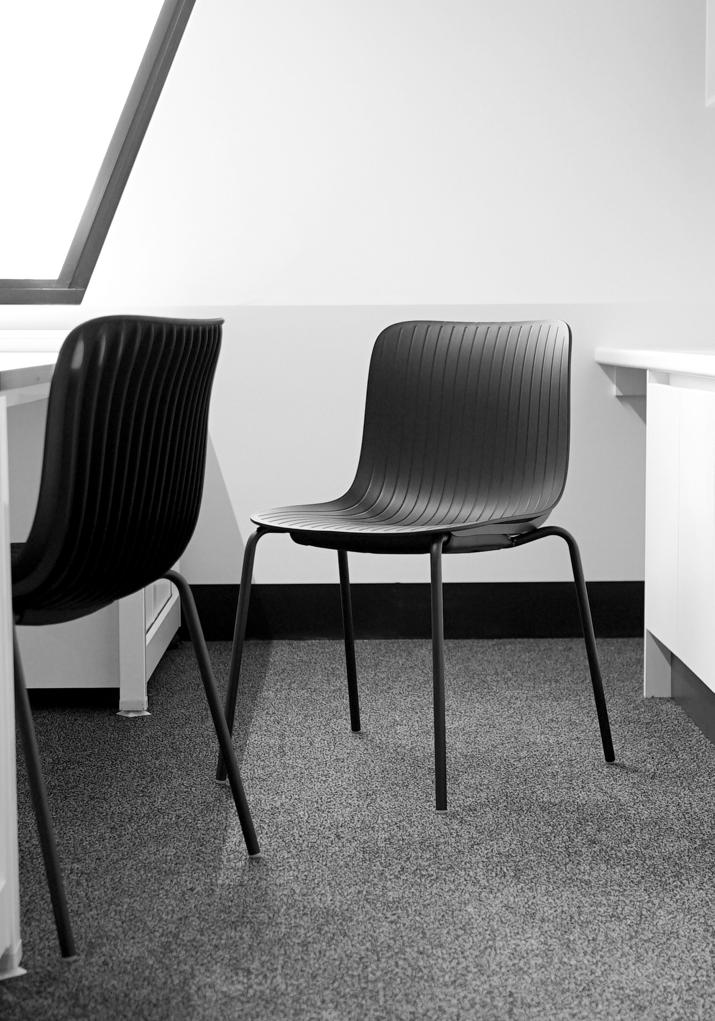 Schwarzer Dragonfly Stuhl von Segis, stapelbar, mit schlankem Design und Metallbeinen.