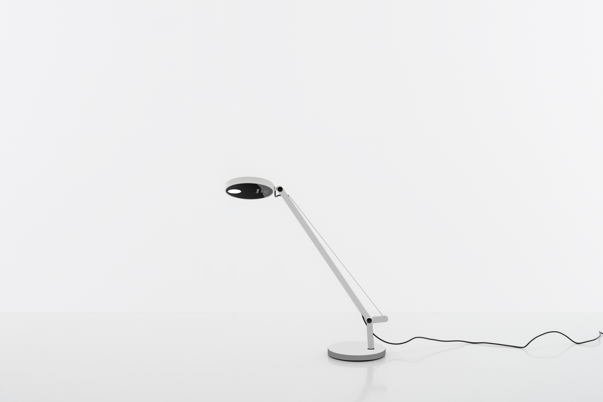 Weiße Artemide Demetra Micro Tischleuchte mit verstellbarem Arm und rundem Leuchtenkopf.