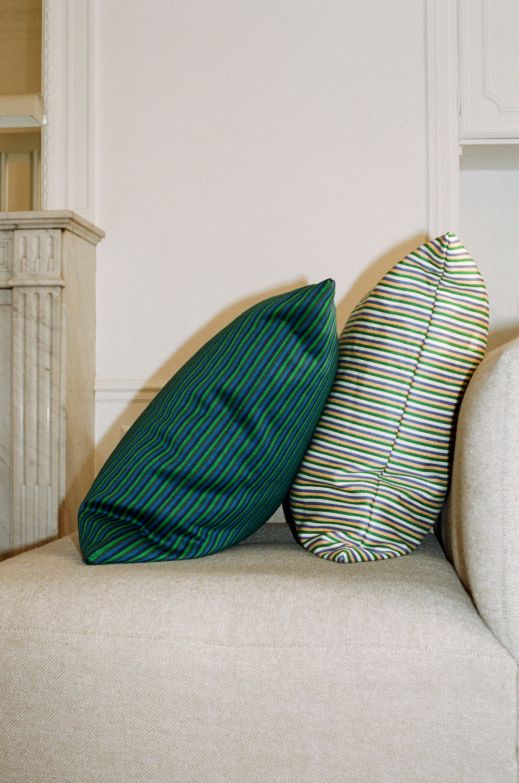 Zwei gestreifte Ribbon Kissen von Hay in Grün-Blau und Bunt auf einem Sofa.