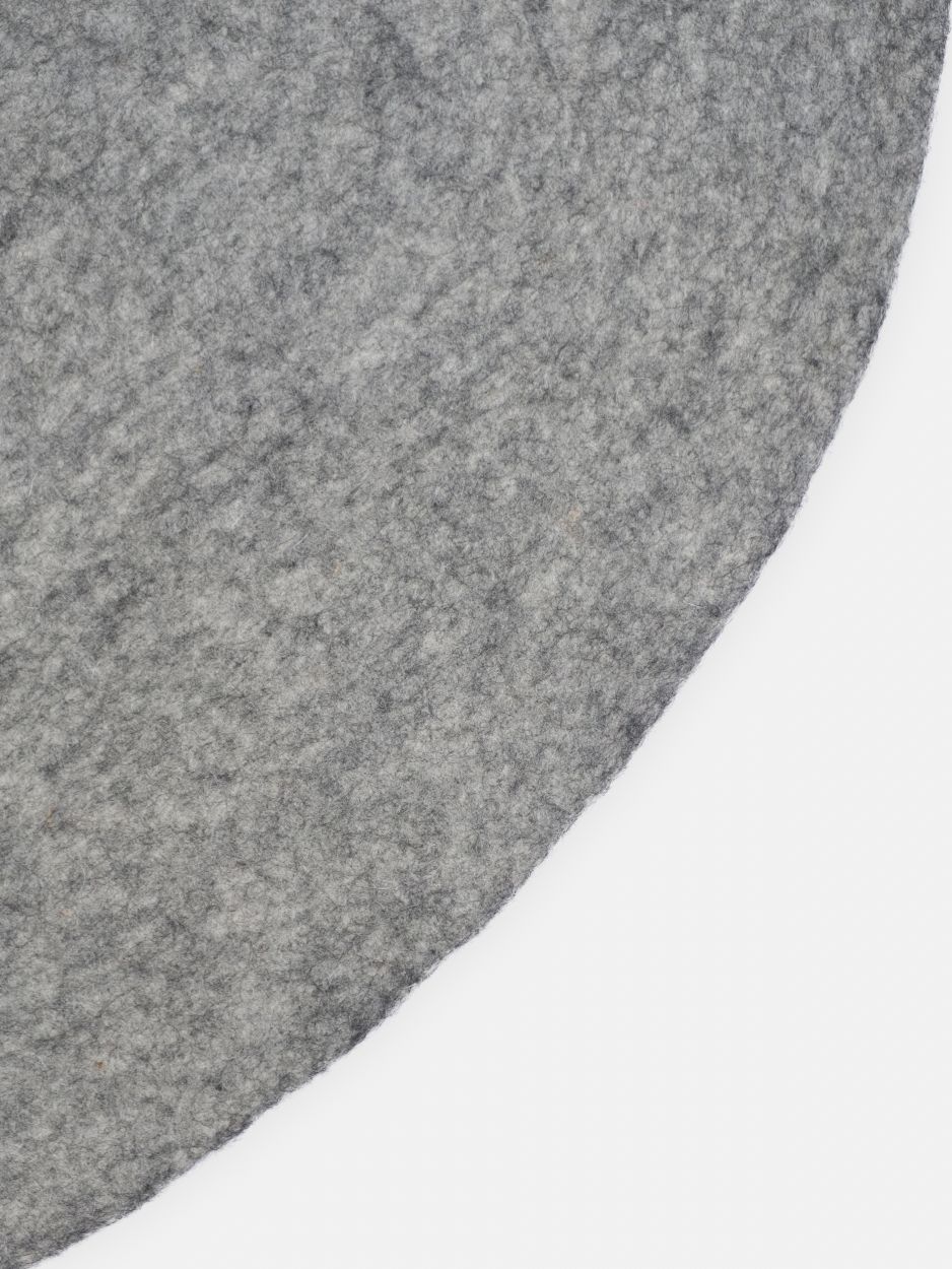 Detailaufnahme des grauen, runden Filzteppichs "myfelt Carl" mit melierter Textur. Ideal als Teppich für Wohnräume.