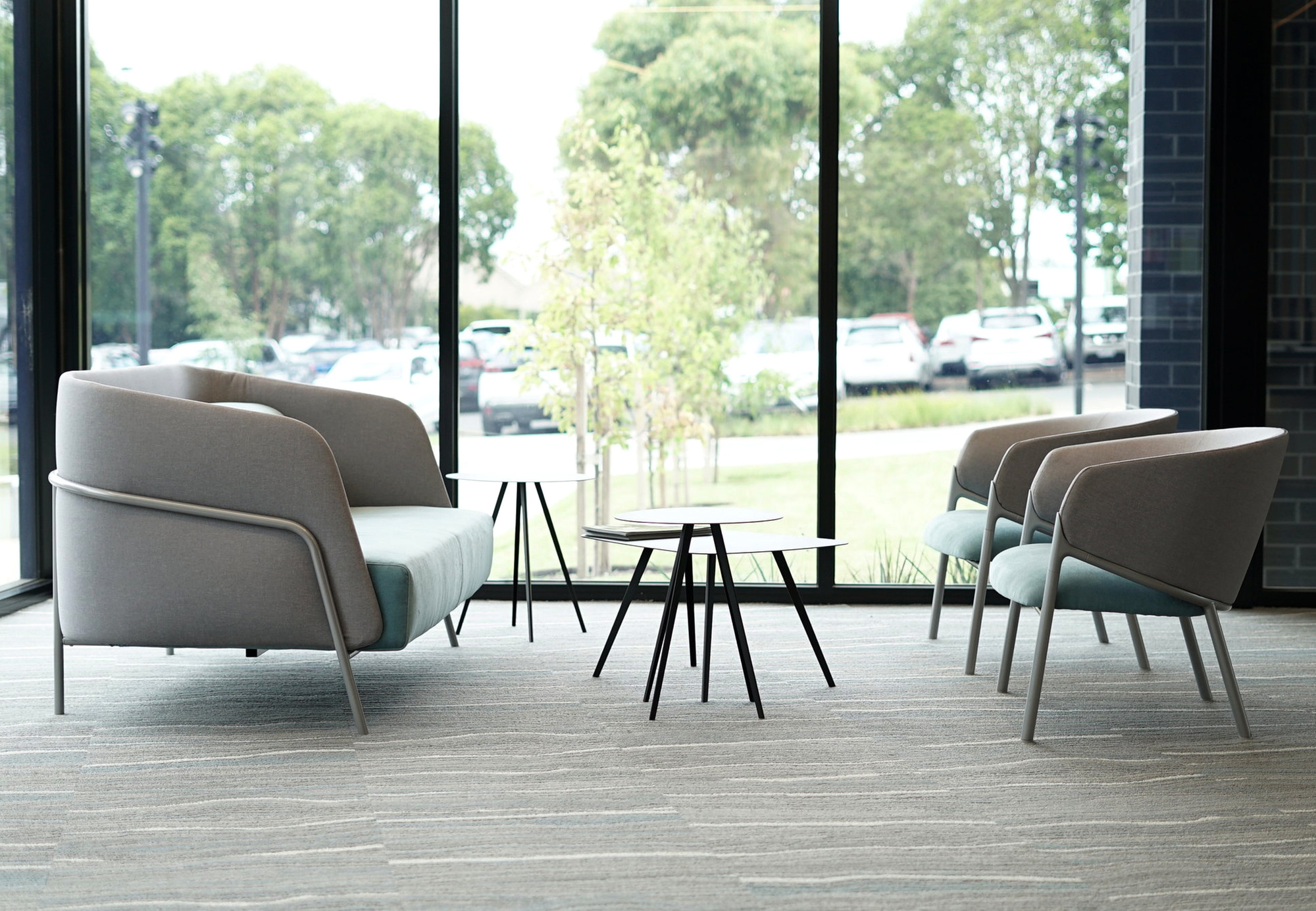 Innenaufnahme mit Agorà Beistelltischen und Stühlen, modernes Design für Wohn- und Bürobereiche.