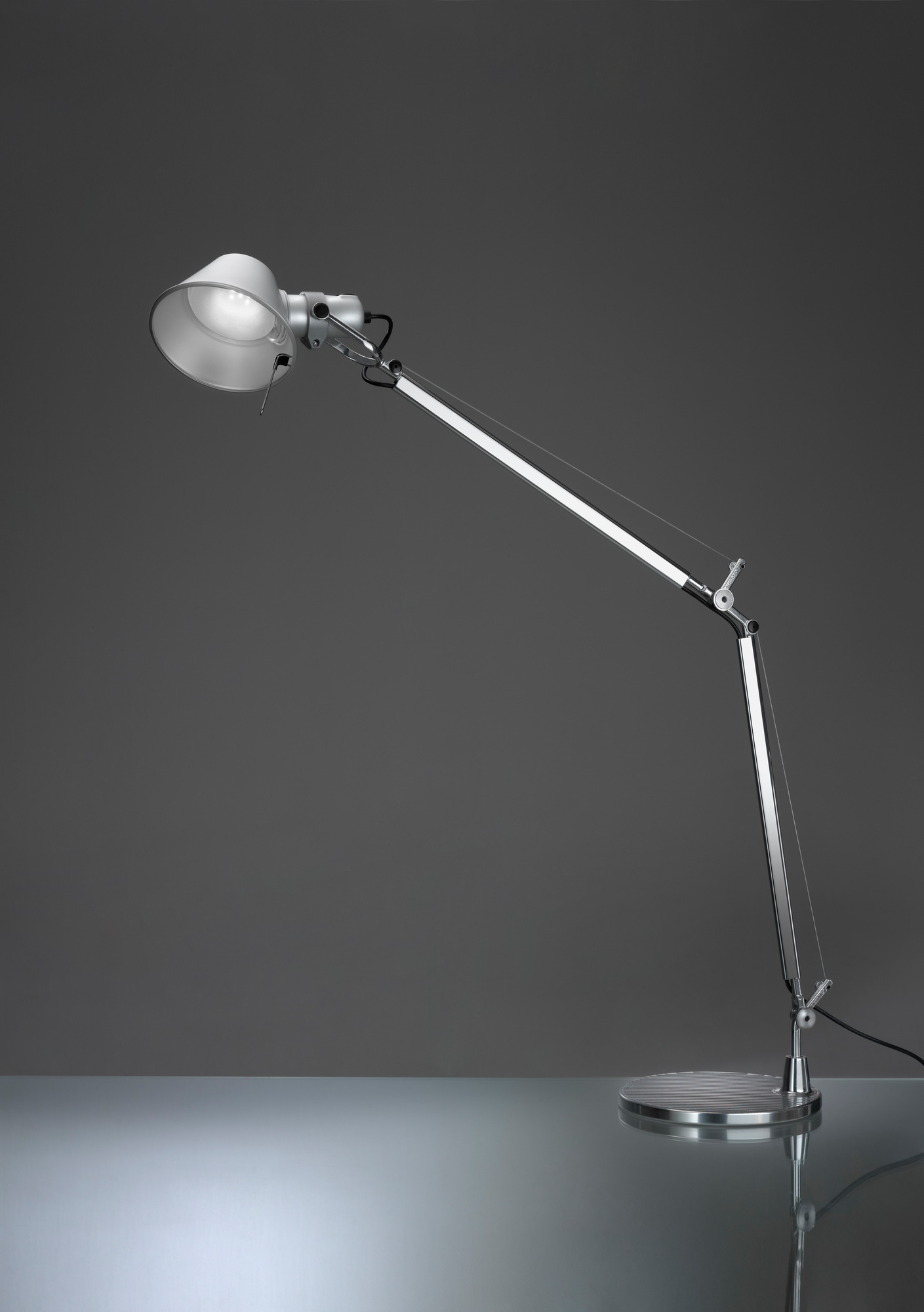 Tolomeo Tischleuchte Tischfuß ø23 Schwarz Artemide (Teil 2 von 2) Nahaufnahme der Artemide Tolomeo Tischleuchte mit schwarzem Fuß, flexiblem Arm und hellem Licht.