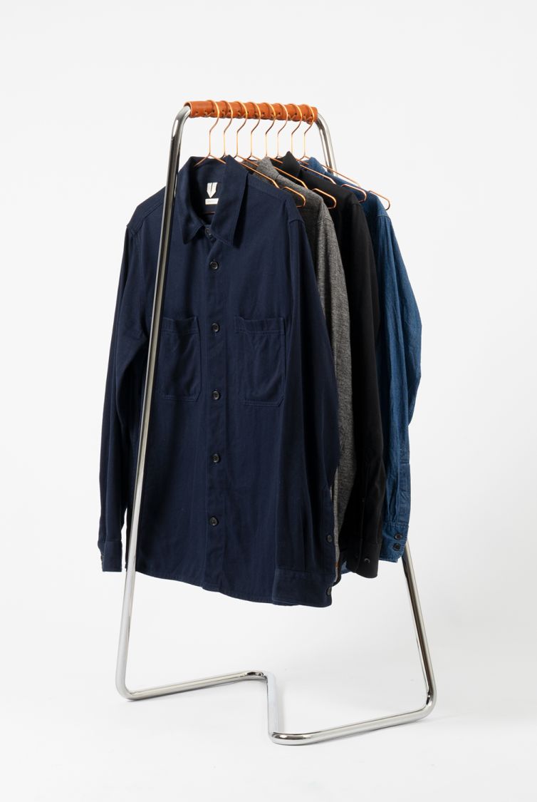 Z10 Fahrrad- und Garderobenständer aus Edelstahl mit Cognac Manschette und hängenden Hemden.