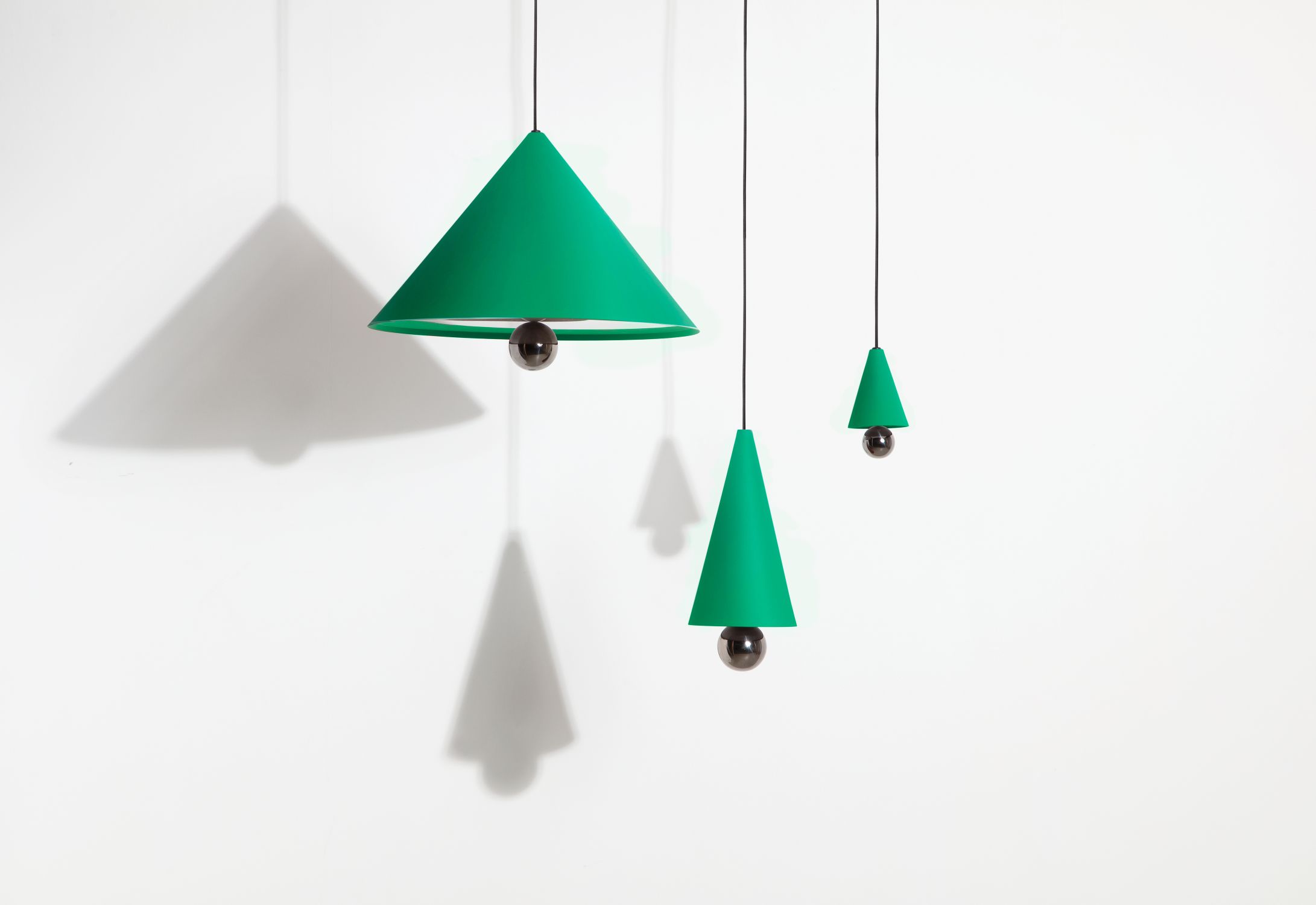 Drei mintgrüne Cherry Pendelleuchten XS von Petite Friture mit runden Leuchtmitteln.