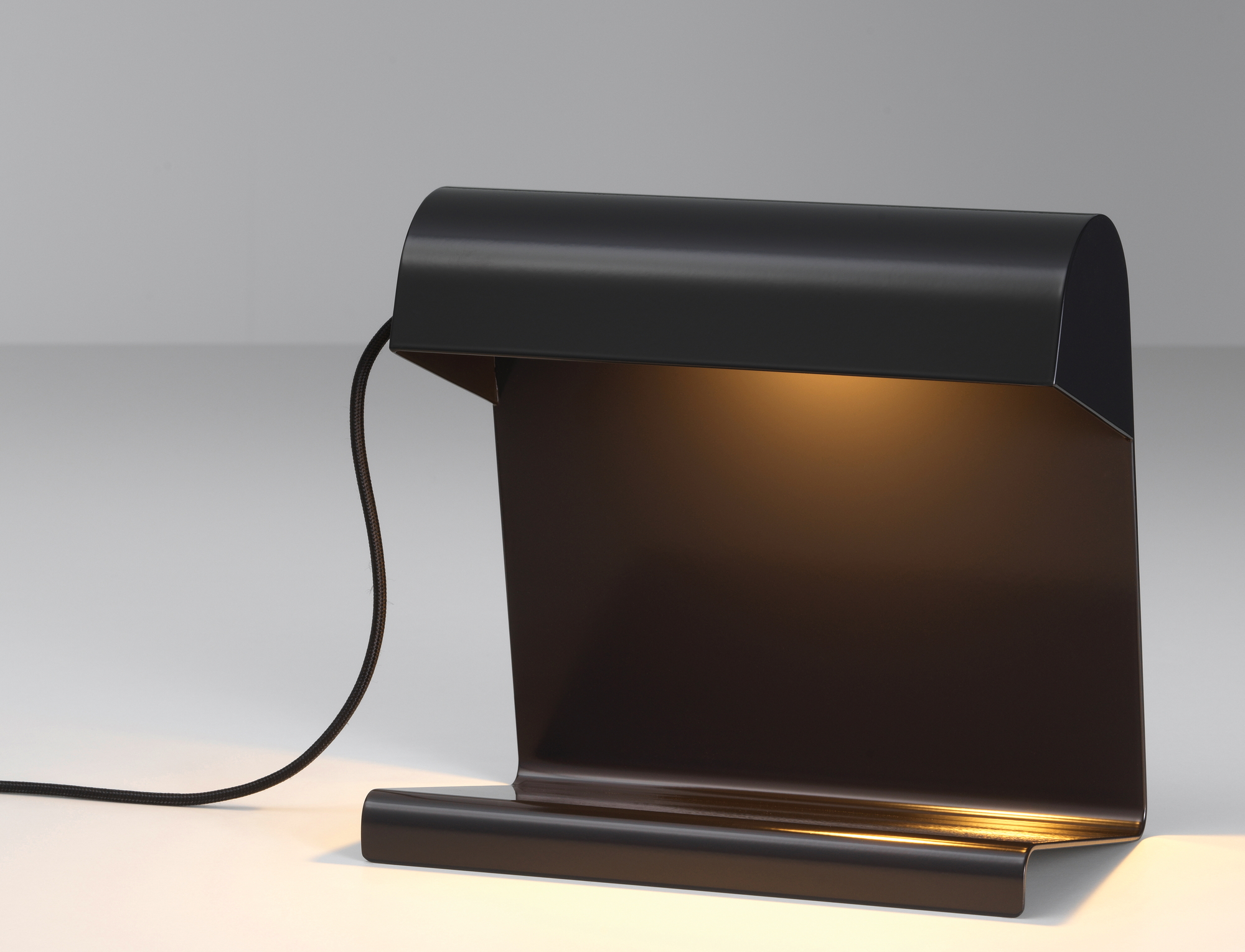 Schwarze Vitra Tischleuchte im minimalistischen Design, spendet warmes Licht für Büro oder Schreibtisch.
