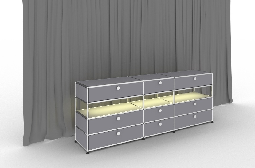 Graues USM Haller Sideboard mit Beleuchtung und neun Schubladen vor grauem Vorhang.