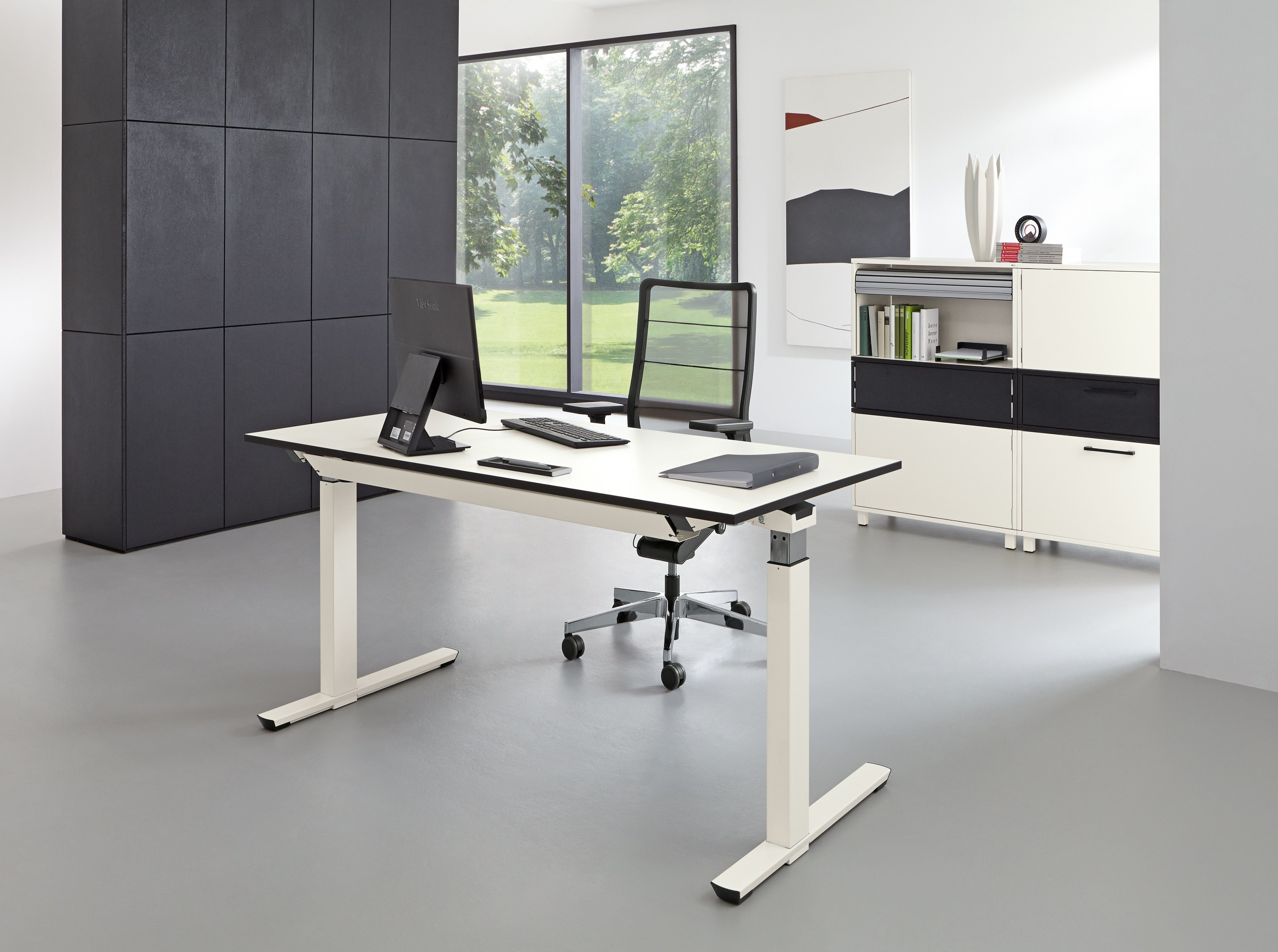 Heller Raum mit Palmberg Crew Schreibtisch, höhenverstellbar, in Weiß mit Büromaterial und Büromöbeln.