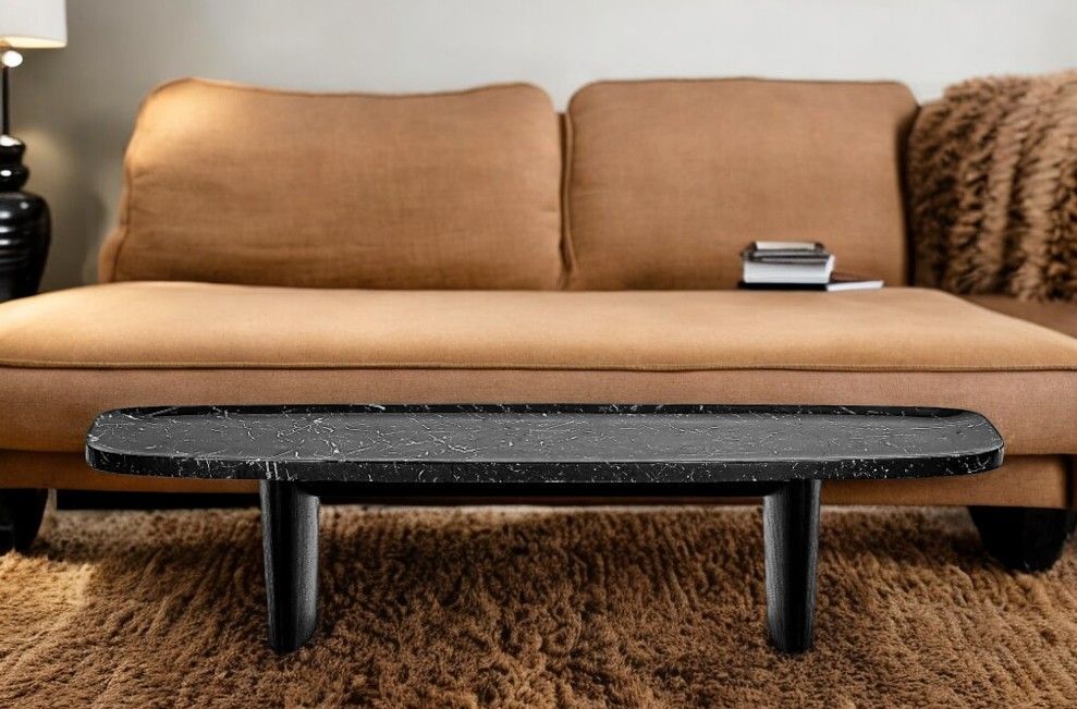 Matéria Couchtisch von Classicon, Nero Marquina Marmor, vor einem braunen Sofa auf Teppich.