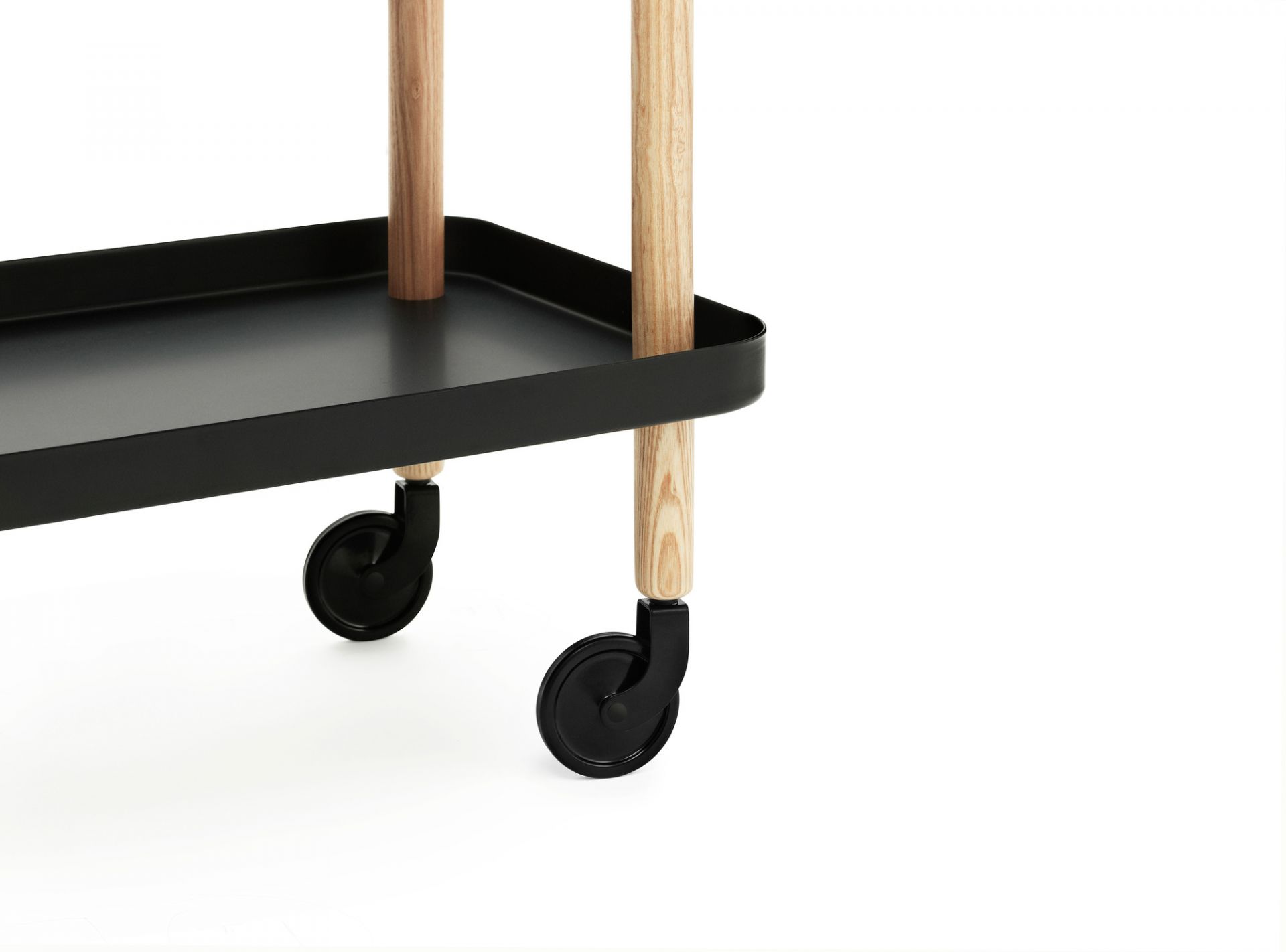 Detailaufnahme des schwarzen Normann Copenhagen Block Table Servierwagens mit Holzbeinen und Rollen.