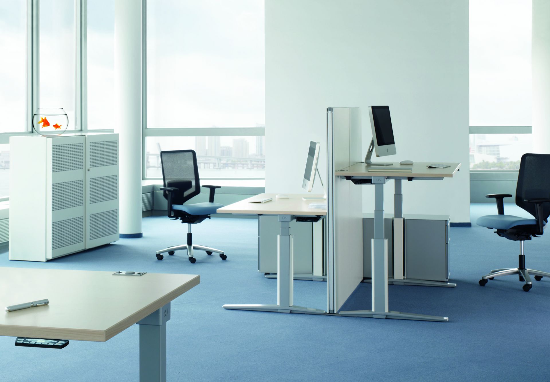 Büro mit höhenverstellbaren Talo.S Konferenztischen von König+Neurath, Bürostühlen, Schränken und Computern in modernem Design.