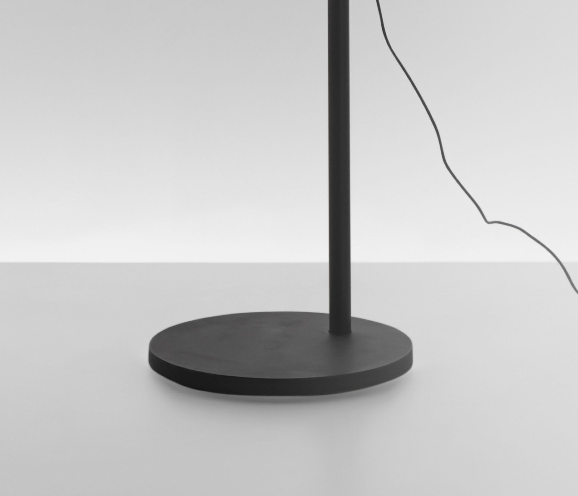 Demetra Stehleuchte: Detailaufnahme der runden Bodenplatte in Schwarz Matt. Artemide Leuchte.