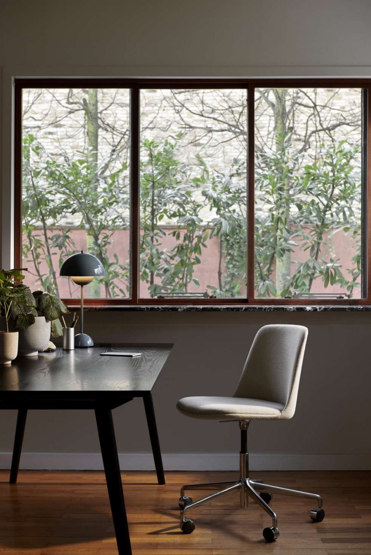 Rely Drehstuhl HW28 von AndTradition in grau, mit Chromfußkreuz und Rollen am Schreibtisch.