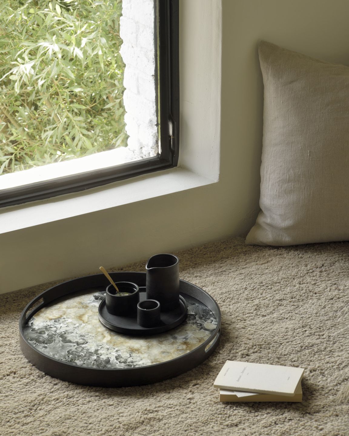 Ethnicraft Dunes Teppich Cumin: Detailaufnahme des beigen Teppichs mit Tablett und Geschirr.
