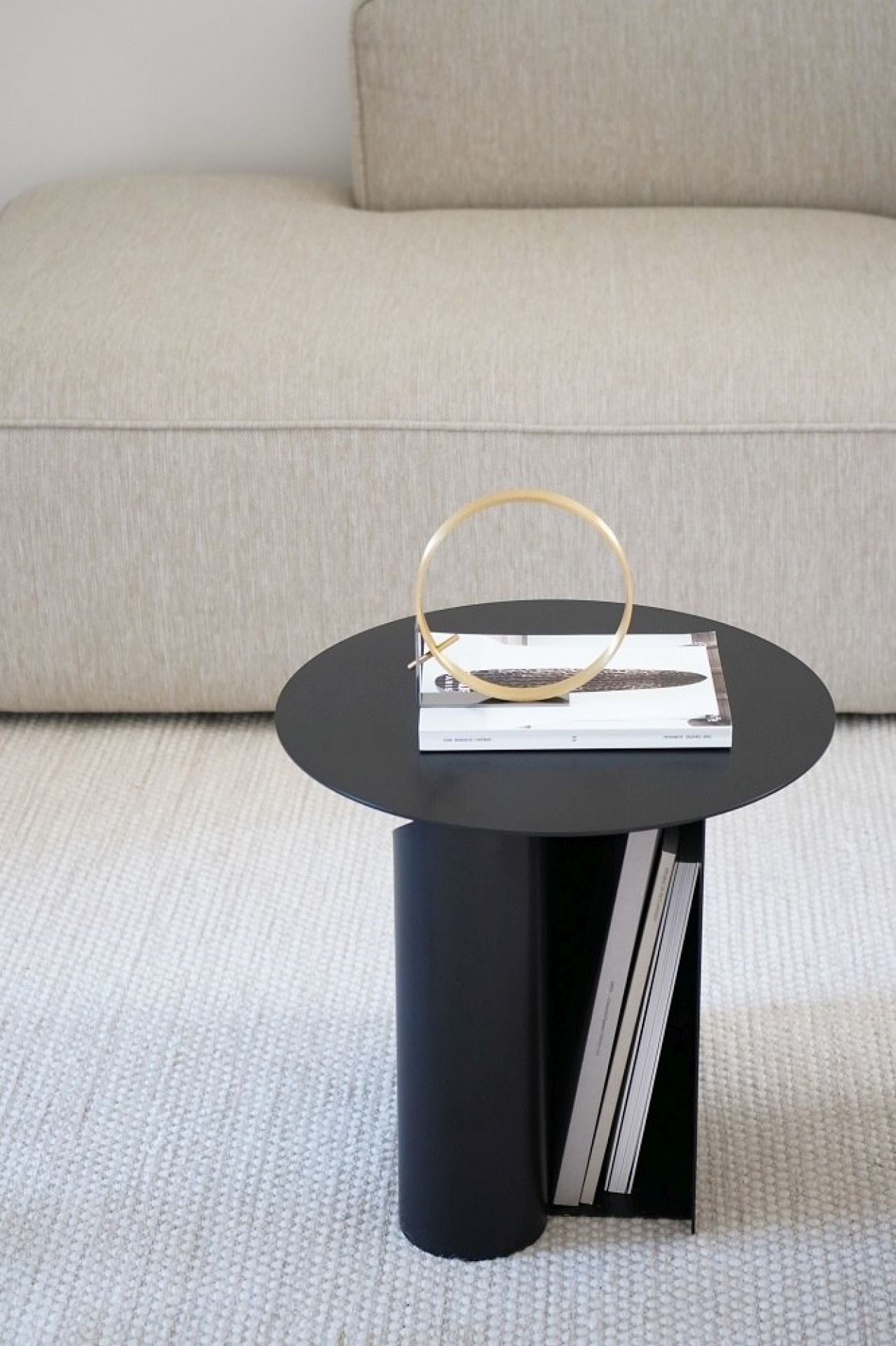 Schwarzer Sentrum Beistelltisch von Woud mit Ablage für Bücher im modernen Wohnzimmer.