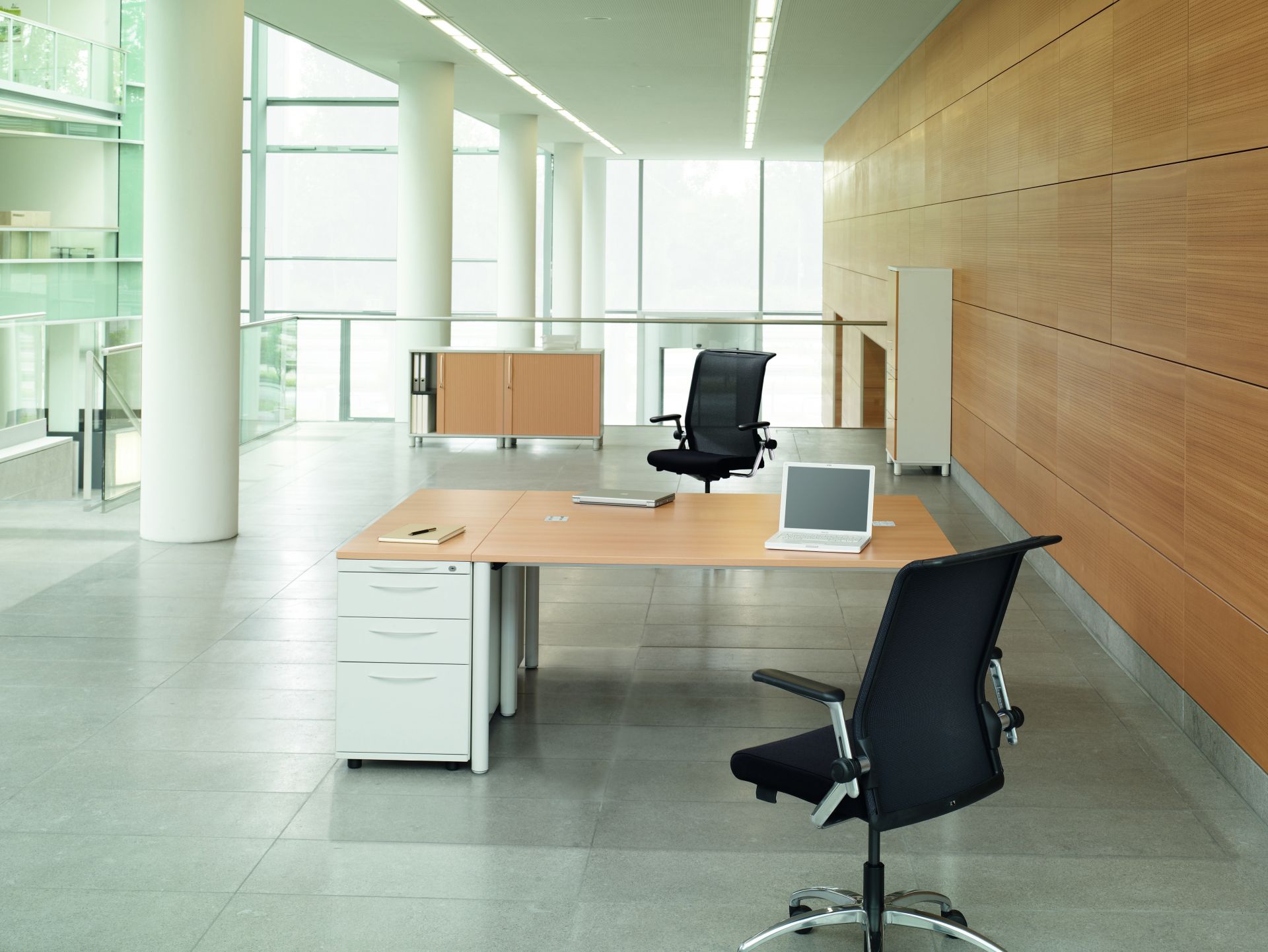 Heller Büroraum mit einem höhenverstellbaren Schreibtisch von König+Neurath, Modell Basic 4, und Bürostühlen.