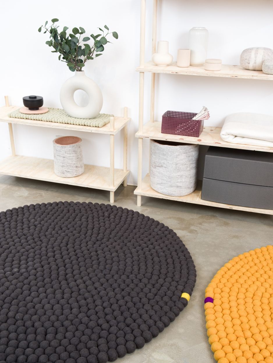 Ockergelber runder Filzteppich von myfelt (Ø 300 cm) aus Filzkugeln auf hellem Boden.