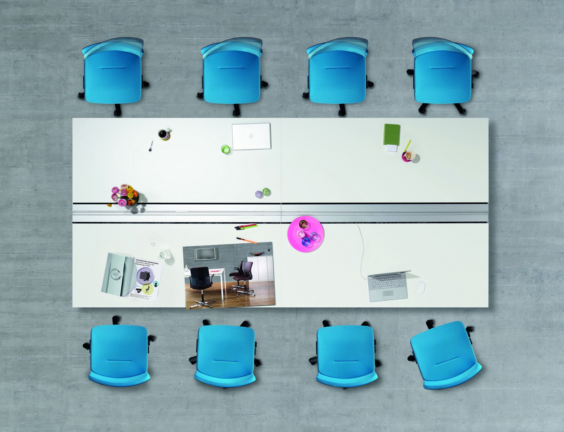 Draufsicht: Lamiga Drehstühle von König+Neurath um einen Bürotisch mit Büroartikeln. Ergonomische Bürostühle in Blau.