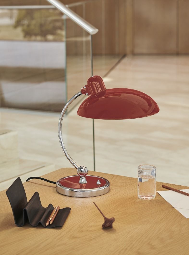 Nahaufnahme der roten Kaiser idell 6631 T Tischleuchte von Fritz Hansen auf einem Schreibtisch.