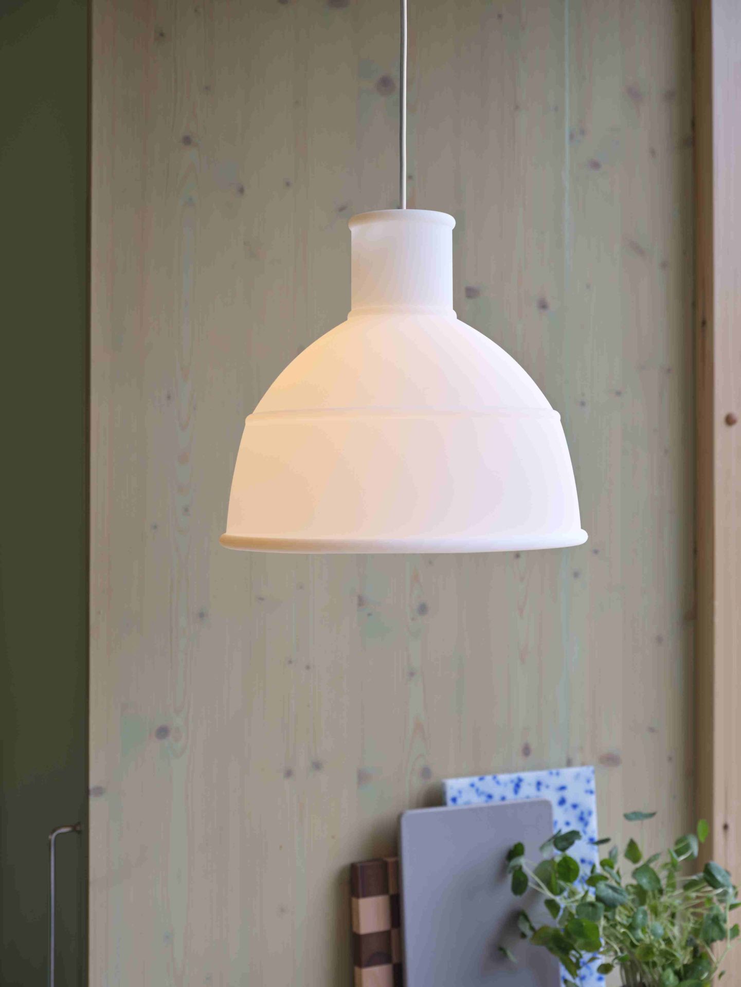 Nahaufnahme der Muuto Unfold Pendelleuchte in transluzentem Weiß, moderne Hängelampe für Wohnzimmer und Esszimmer.