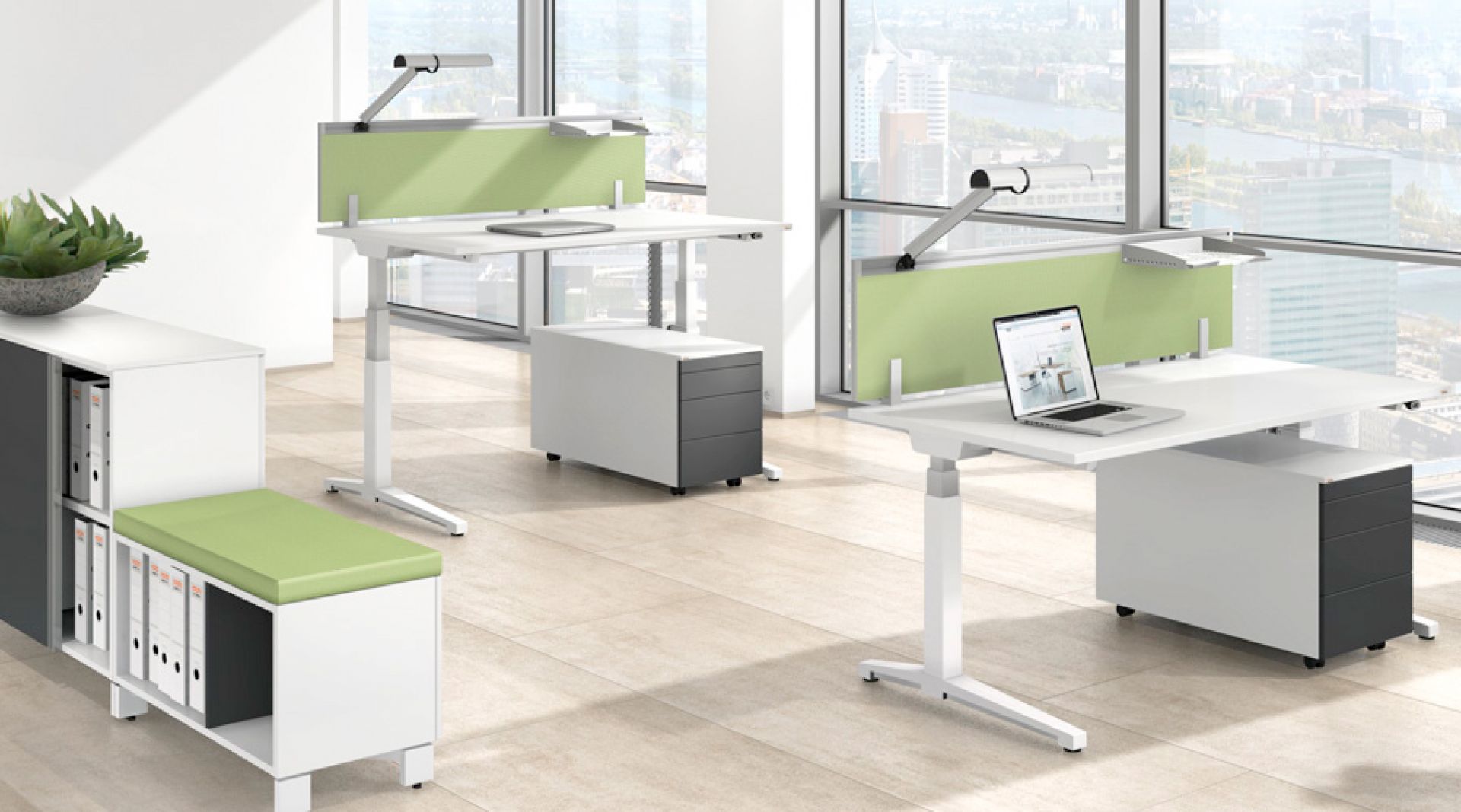 Moderner, höhenverstellbarer Schreibtisch von Assmann Büromöbel mit Laptop und Rollcontainer vor einem Fenster.