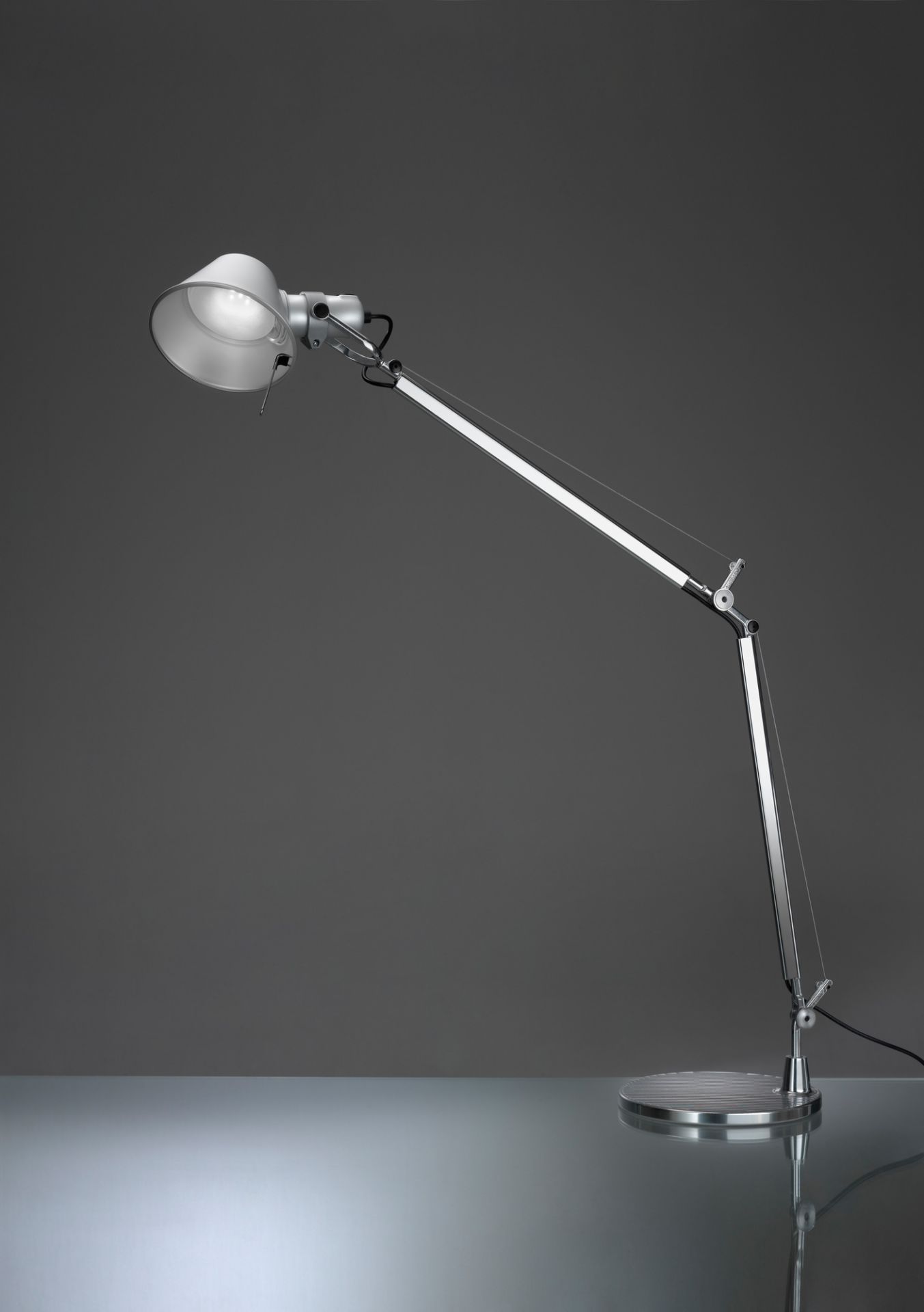 Tolomeo Tischleuchte Tischfuß ø23 Schwarz Artemide (Teil 2 von 2) Nahaufnahme der Artemide Tolomeo Tischleuchte mit schwarzem Fuß, flexiblem Arm und hellem Licht.