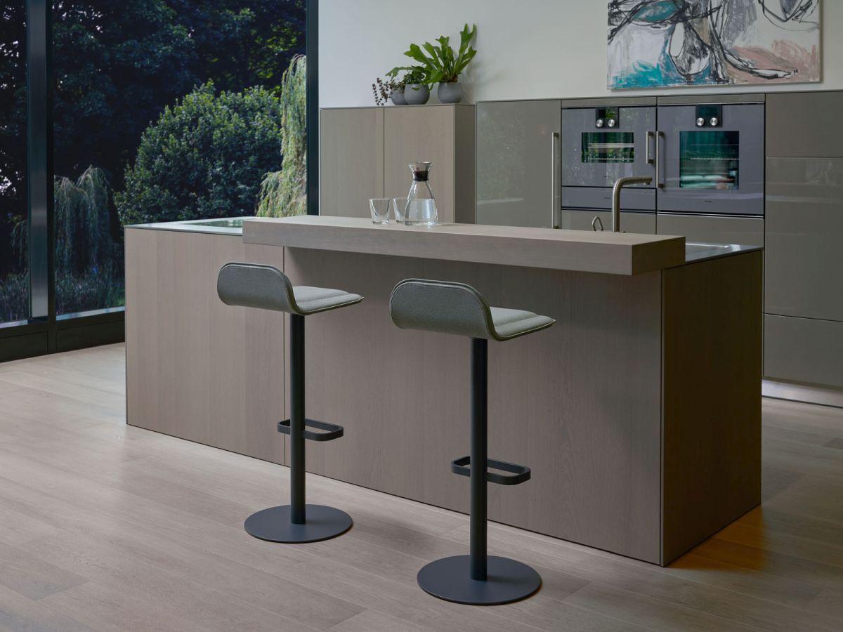 Anthrazitfarbener Dave Barhocker von Moree mit weinrotem Sitzpolster vor moderner Kücheninsel.
