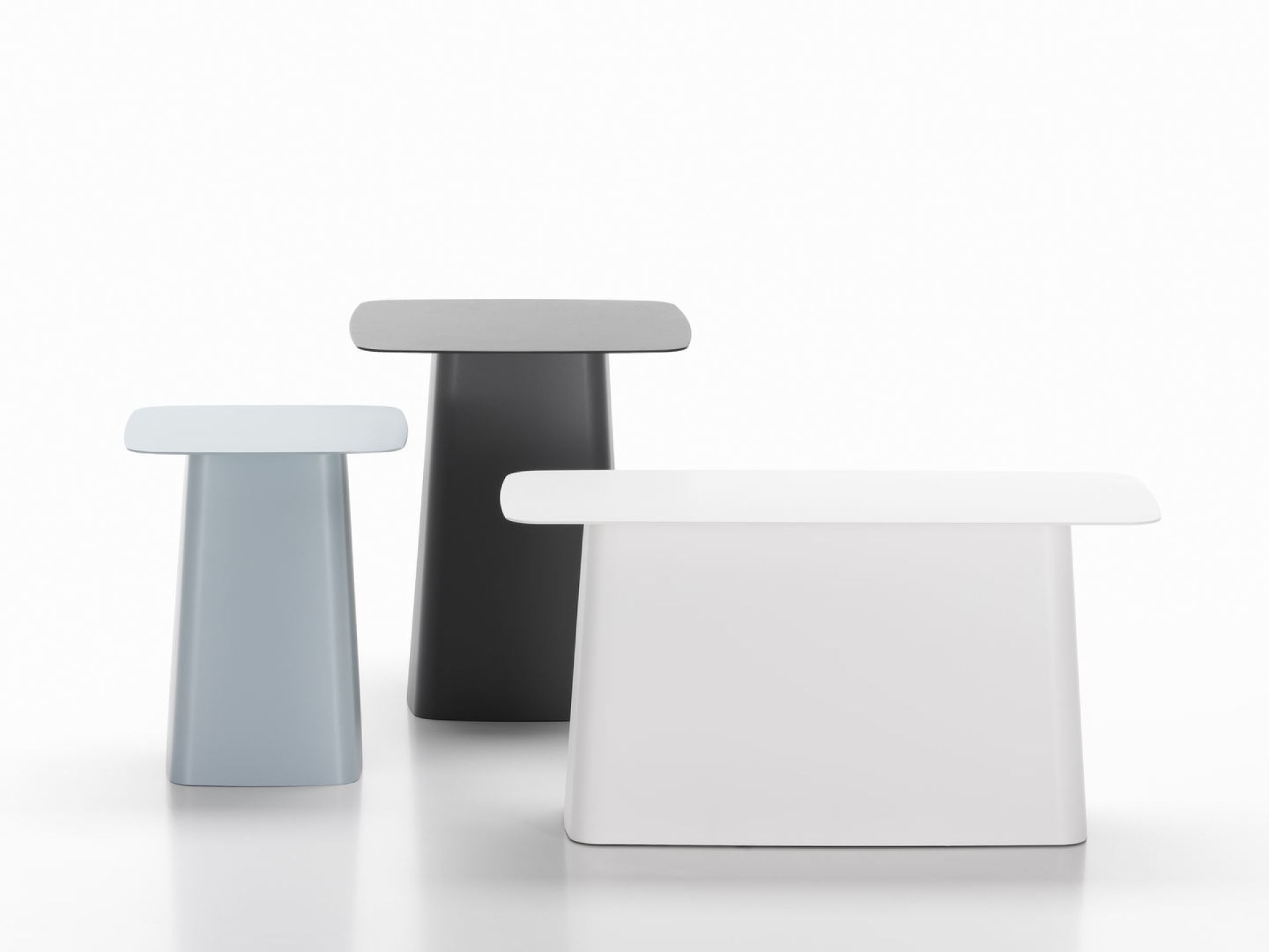 Drei Metal Side Table Beistelltische von Vitra in Weiß, Grau und Schwarz vor weißem Hintergrund.