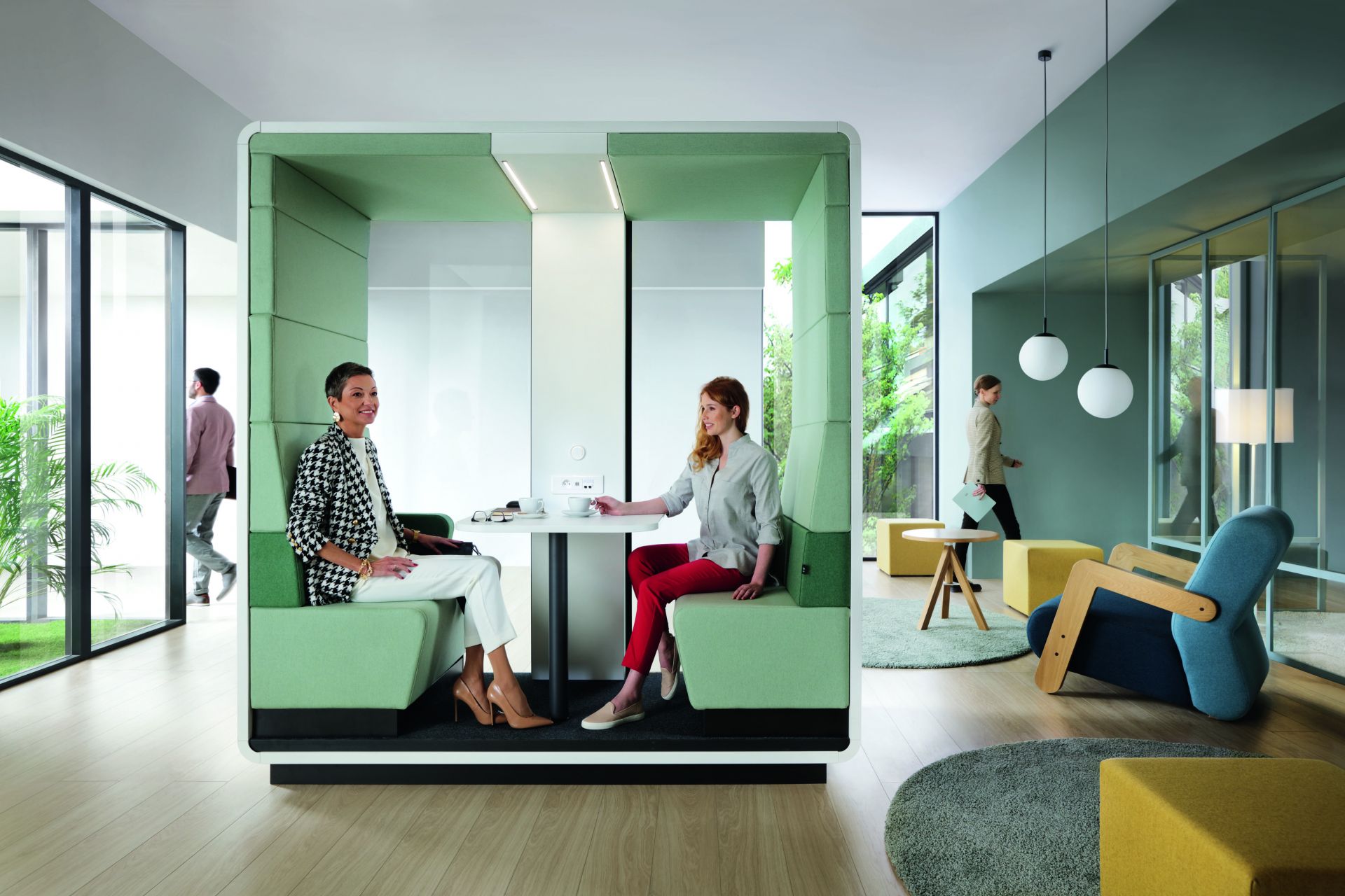 Zwei Frauen im HushMeet.Open Meetingbox von Mikomax, moderner Besprechungsraum für Büro und Konferenz.