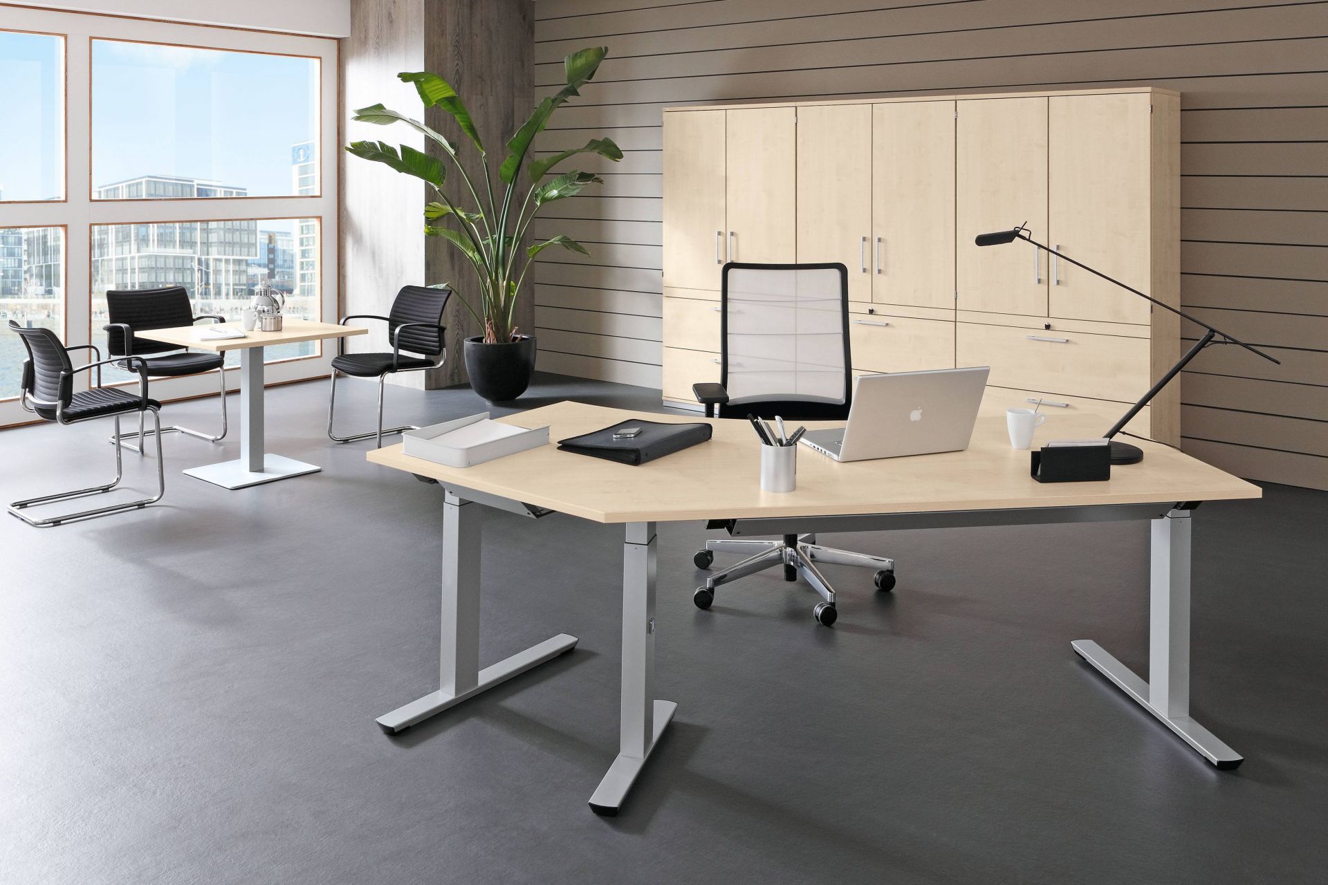 Büro mit Palmberg Crew Sitz-Stehtisch, höhenverstellbar, mit Büromöbeln und Büropflanze.