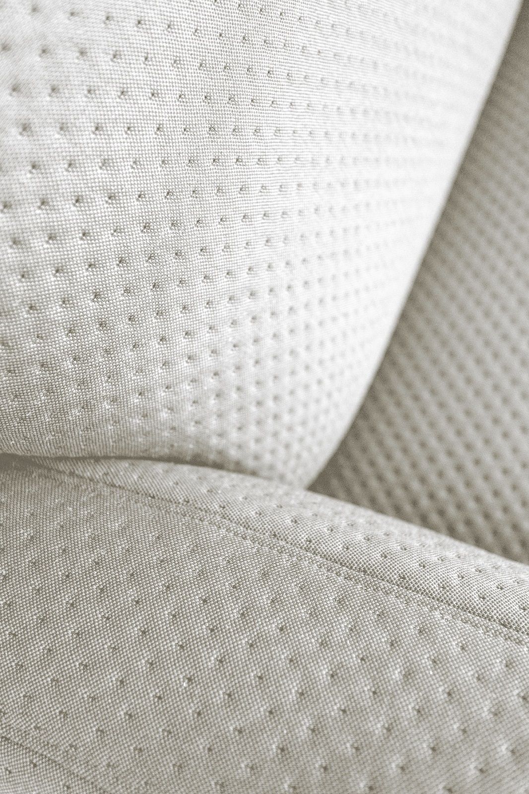 Detailaufnahme des hellen, strukturierten Stoffbezugs vom Hartô Auguste Sofa. Hochwertige Polsterung und feine Nähte.