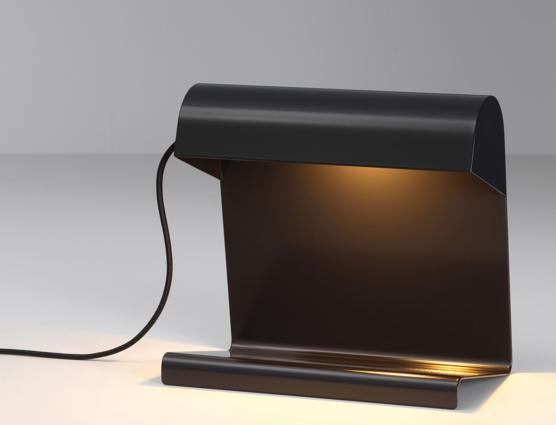 Schwarze Vitra Tischleuchte im minimalistischen Design, spendet warmes Licht für Büro oder Schreibtisch.