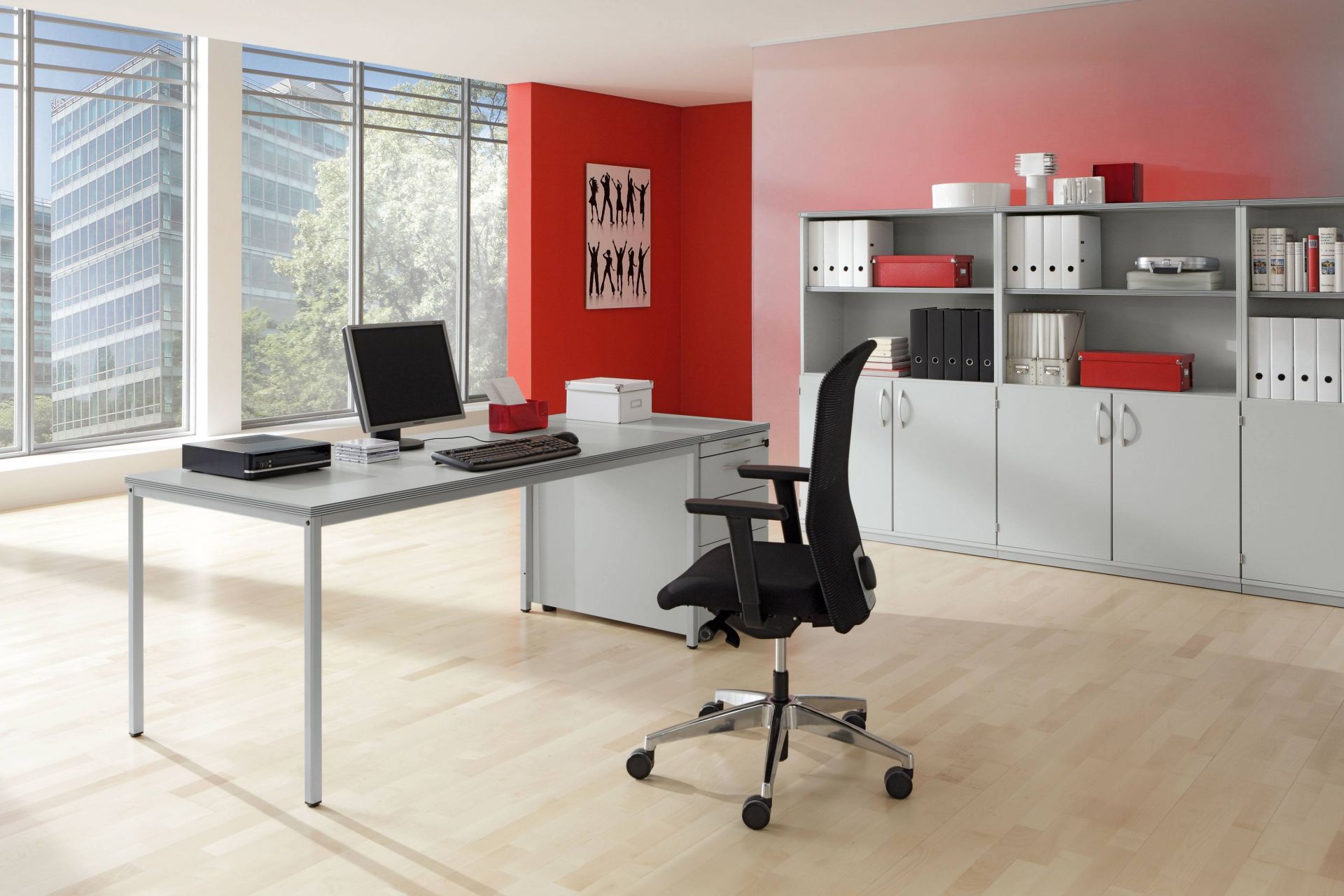 Büro mit Palmberg Intro Tec Tisch, Bürostuhl, Schrankwand und Computer vor Fenster.