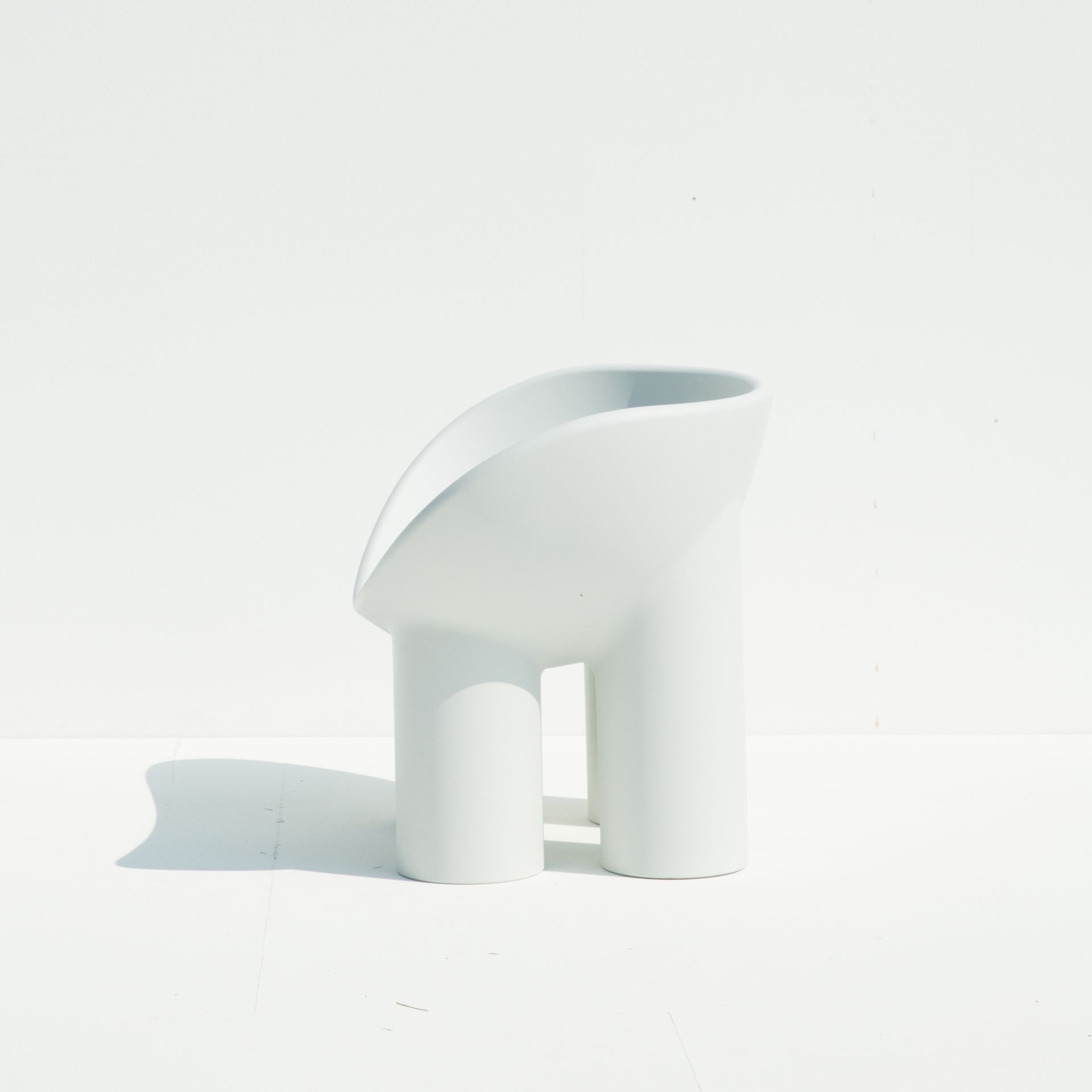 Weißer Roly Poly Sessel von Driade Concrete, modernes Designmöbel mit zwei Beinen und geschwungener Sitzfläche.