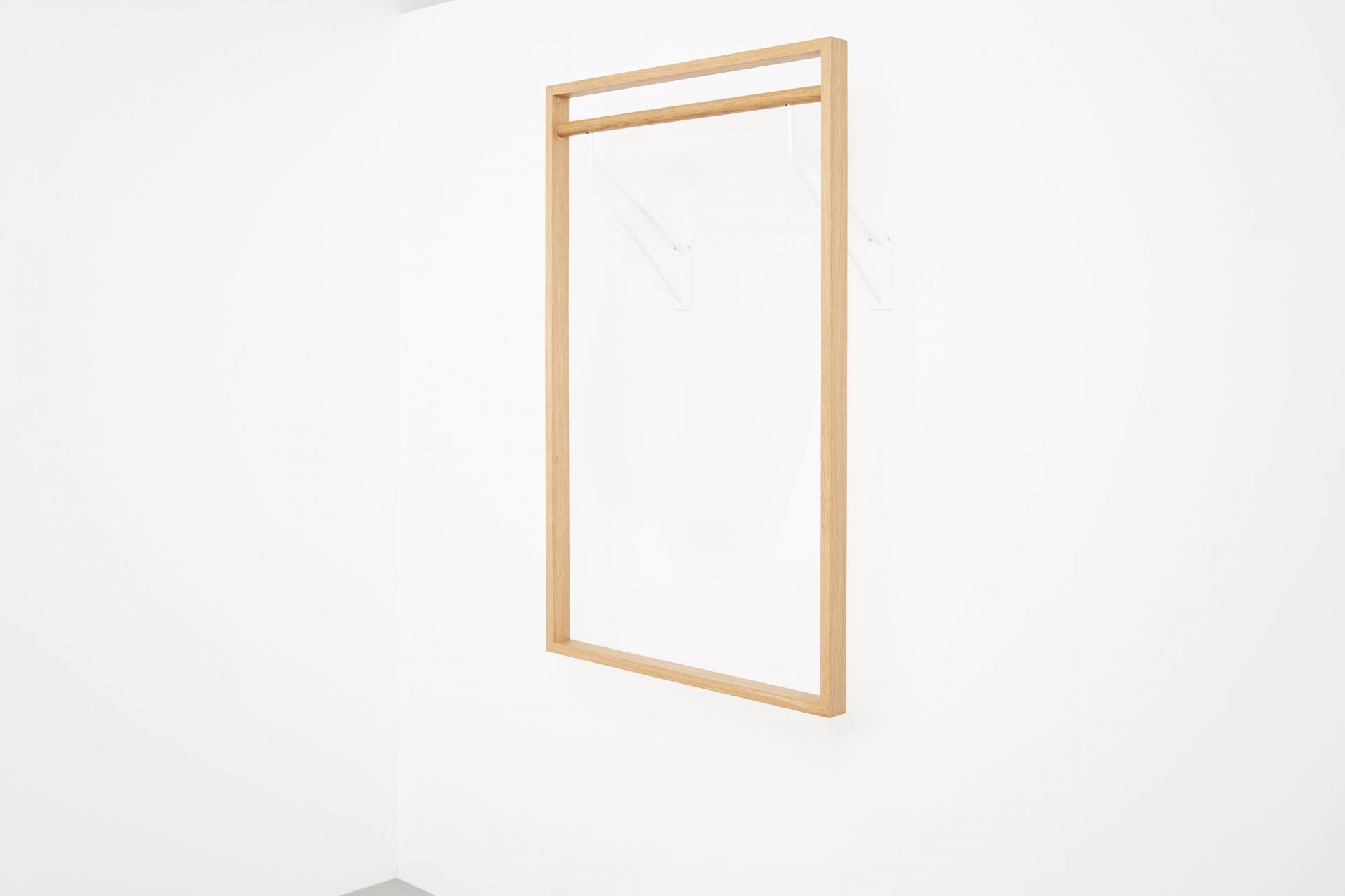 gardero-b 2 Wandgarderobe: Helle Holzgarderobe mit weißen Halterungen an einer weißen Wand.
